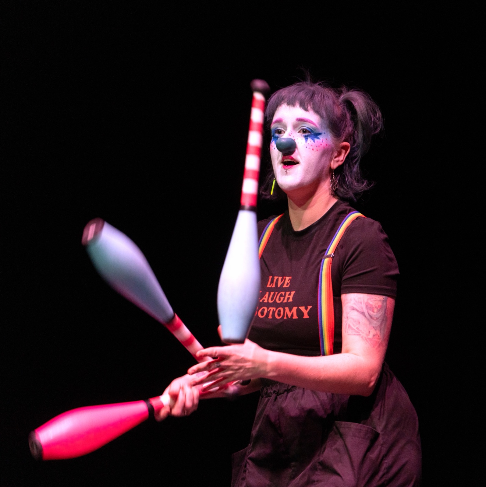 Chow juggling clubs in clown makeup