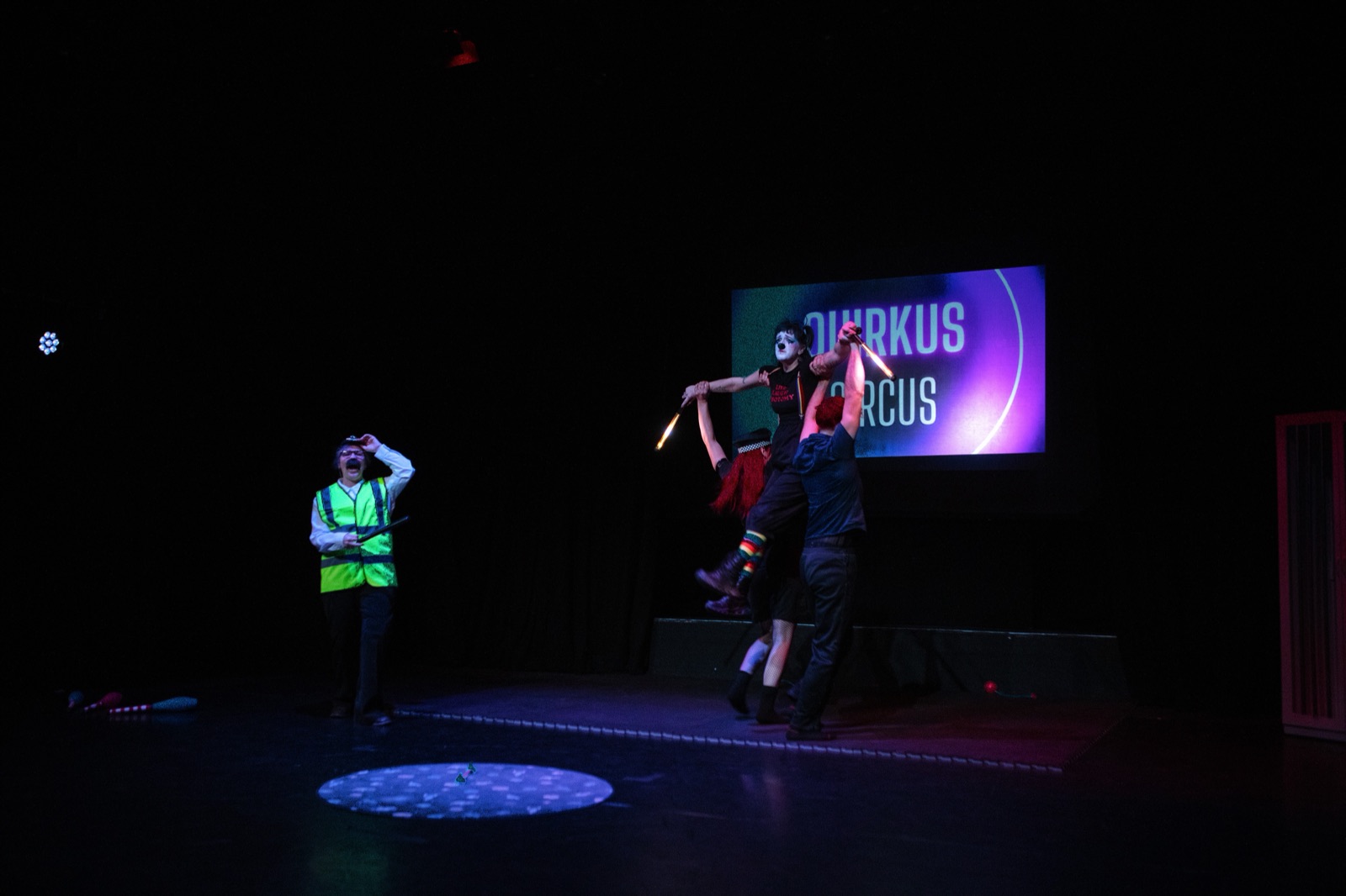 Ensemble circus performance on a dark stage